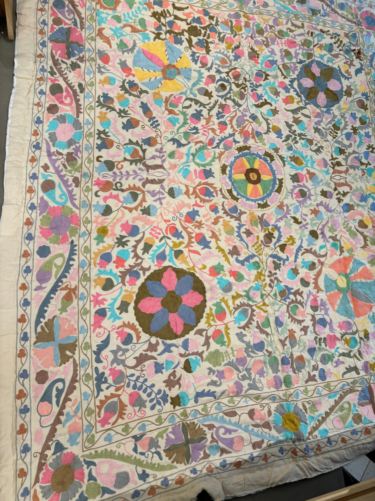 Colorful embroidered textile with intricate patterns on a plain background. Handmade Indian Hand Embroidered Queen Size Quilt. Colorful Floral Suzani Kantha Style Quilt. Artisan Cotton Bedspread.