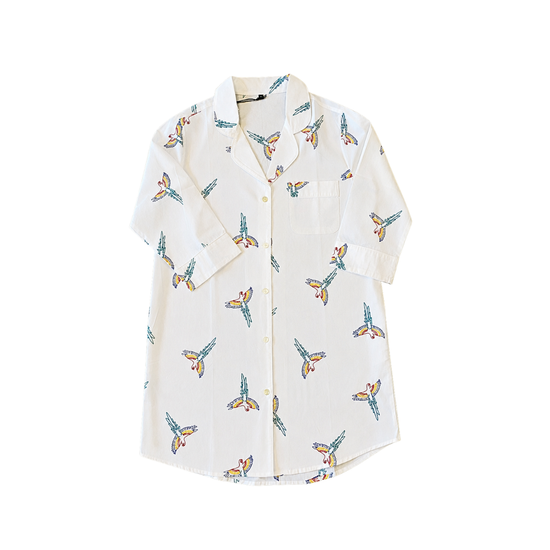 White shirt with colorful butterfly pattern on a white background. Size large crisp white cotton long-sleeve pajama shirt featuring artisan hand-stitched tropical parrot details.