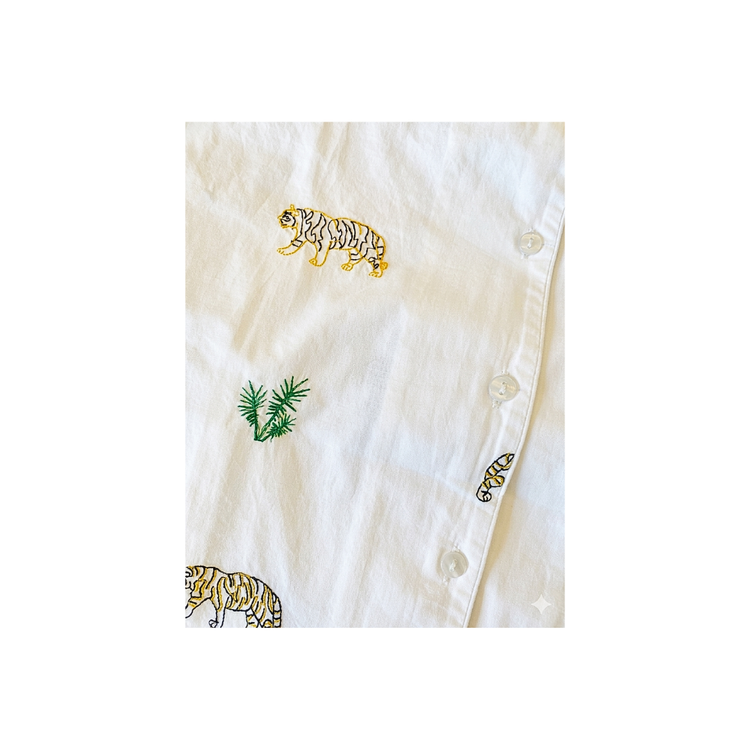 White shirt with embroidered tiger and leaf designs on a white background